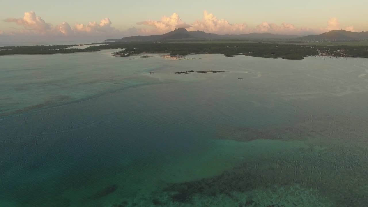 Vista aerea dell'acqua blu dell'oceano con onde, coralli e piante acquatiche, telecamera che si muove verso la costa, Isola di Mauritius