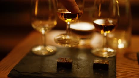 hand reaching for whisky glass on table