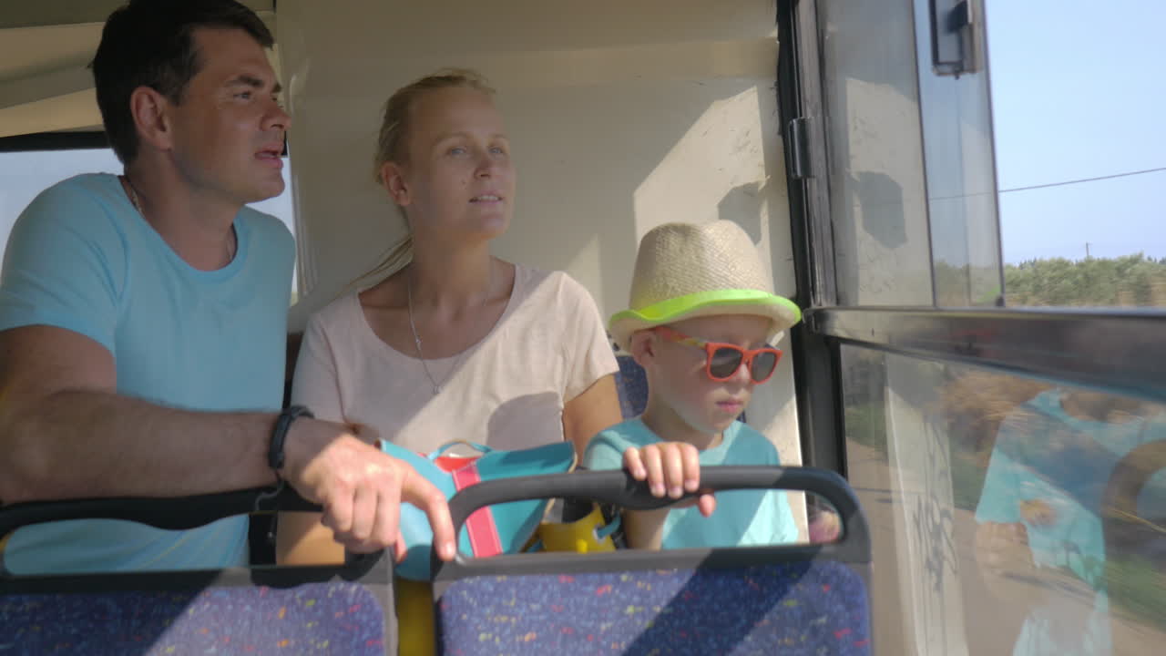 Famiglia con bambino che viaggia in autobus e guarda fuori dal finestrino