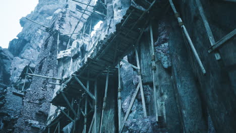 ancient ruins with scaffolding under gray cloudy sky in mountainous region