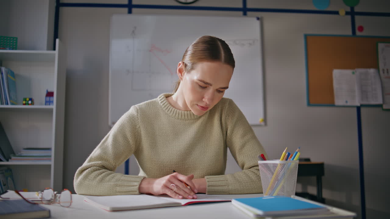 Positive girl working school at class room closeup. Woman teacher putting marks