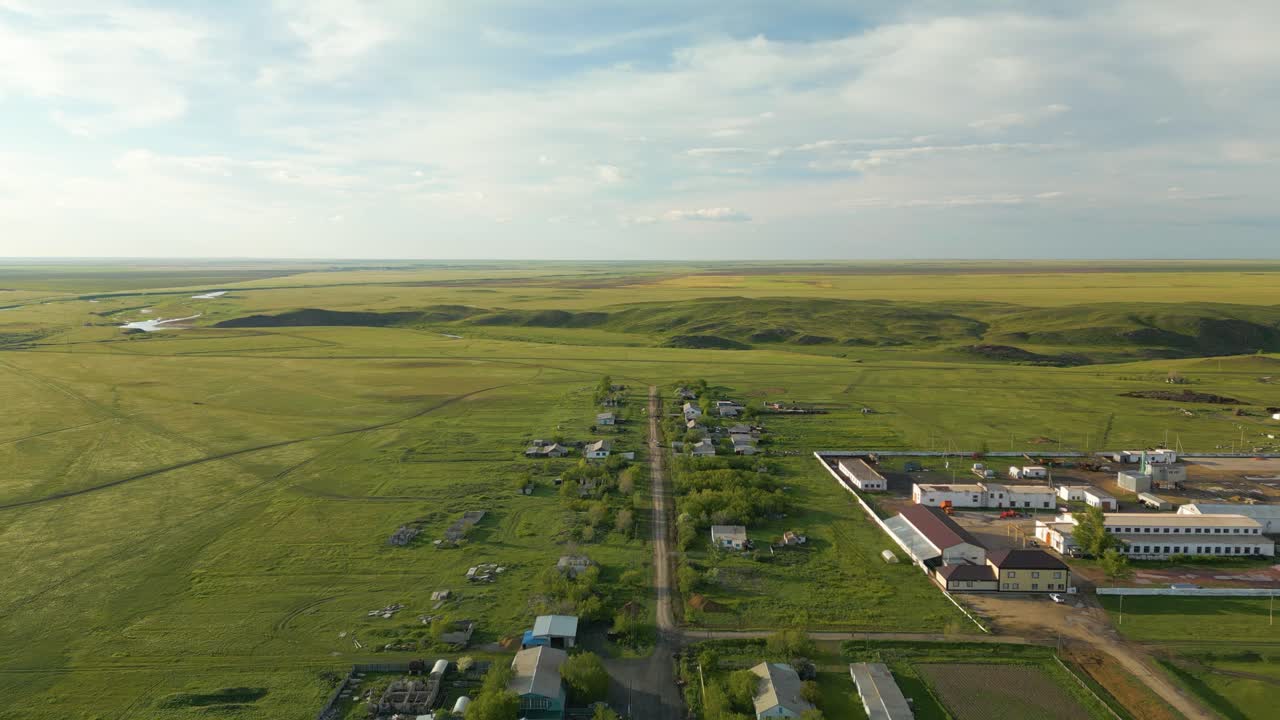 카자흐스탄, 중앙아시아의 길 근처의 초록색 에 위치한 집들의 줄과 개인 구조물 - 드론이 앞으로 날아갑니다.