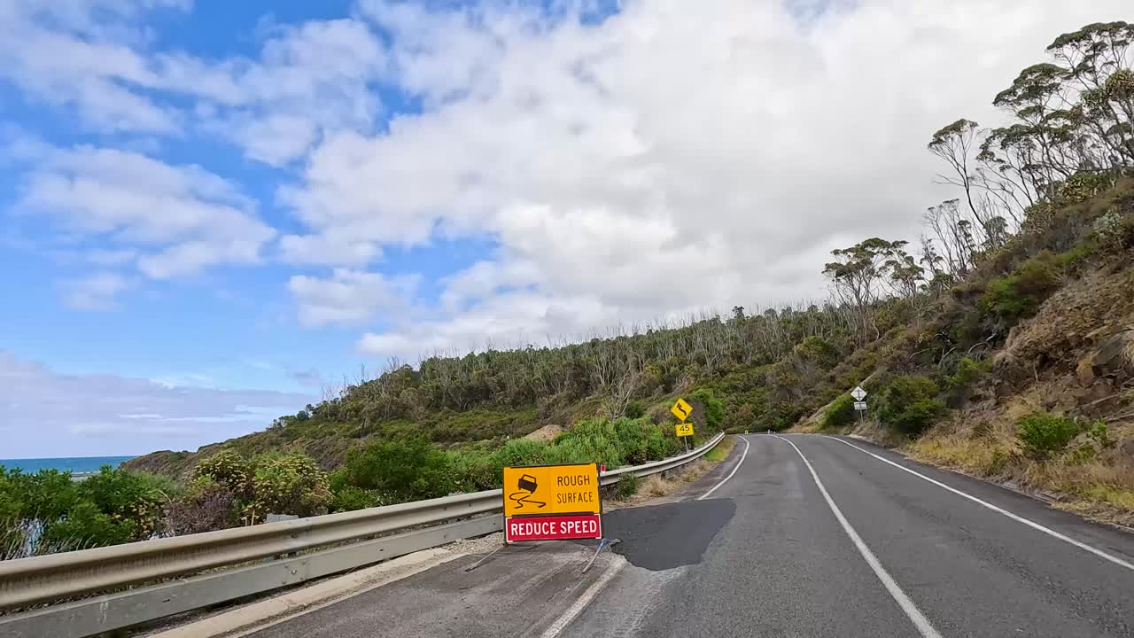 A 15-second journey along the Great Ocean Road, showcasing winding roads, coastal views, and lush greenery under a bright sky