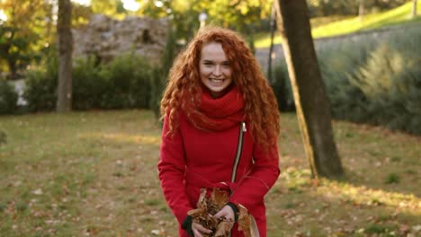 Retrato-De-Una-Mujer-Pelirroja-Feliz-Tirando-Hojas-Y-Mirando-Hacia-Arriba-En-Un-Día-De-Otoño-1