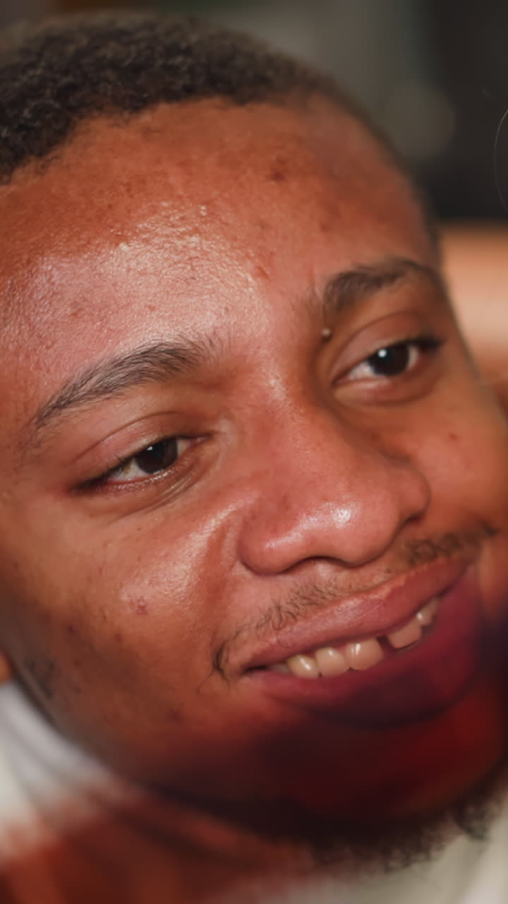 Cheerful African-American guy with white woman looks at processed coloured film enjoying vintage images in studio closeup slow motion