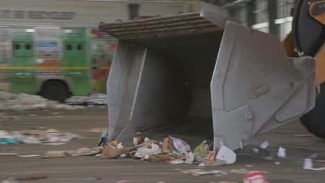 excavadora o cargadora empujando un montón de desechos de cartón en una fábrica de reciclaje