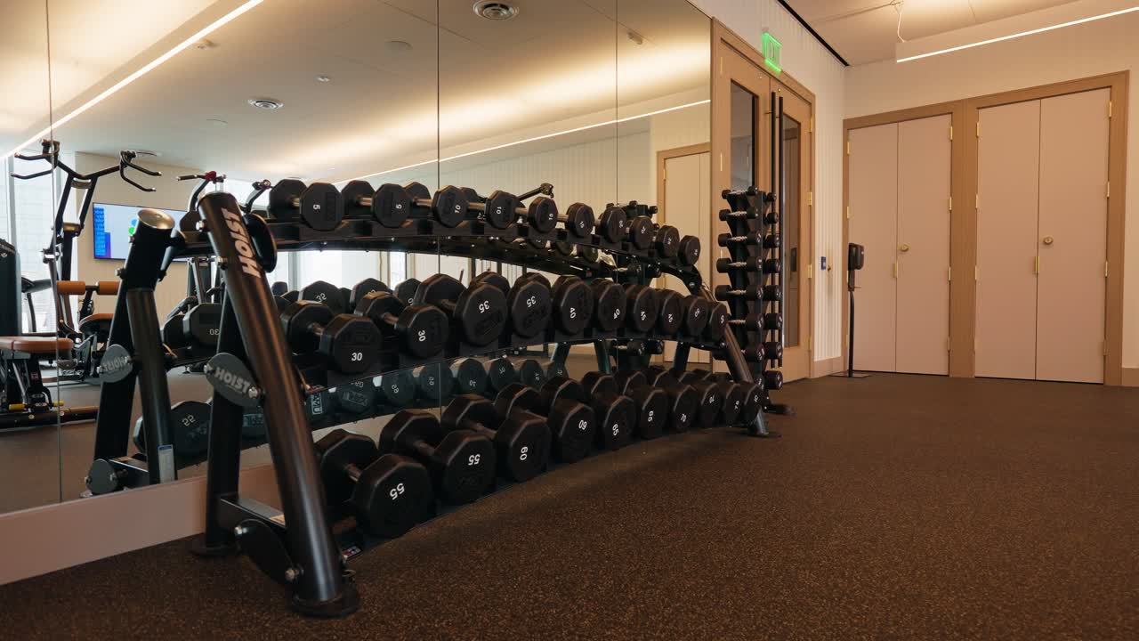 Shot of a dumbbell rack in the fitness center, showcasing a variety of black dumbbells neatly arranged