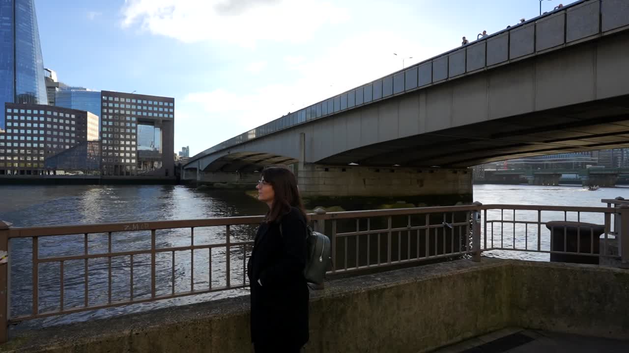 Woman enjoying view of The Shard and Thames River by London Bridge on a sunny day
