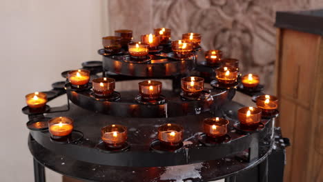 Velas-Encendidas-En-El-Estante-De-Velas-Votivas-Dentro-De-La-Iglesia.