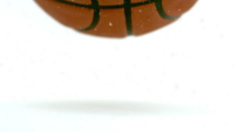 animation of snowflakes falling over bouncing basketball, on white background