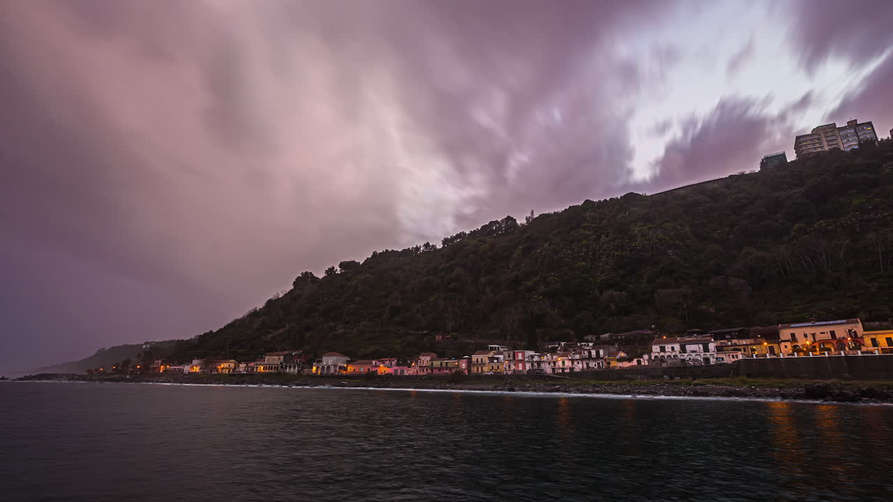 Timelapse di nuvole di pioggia viola con la costa della Sicilia al crepuscolo in Italia
