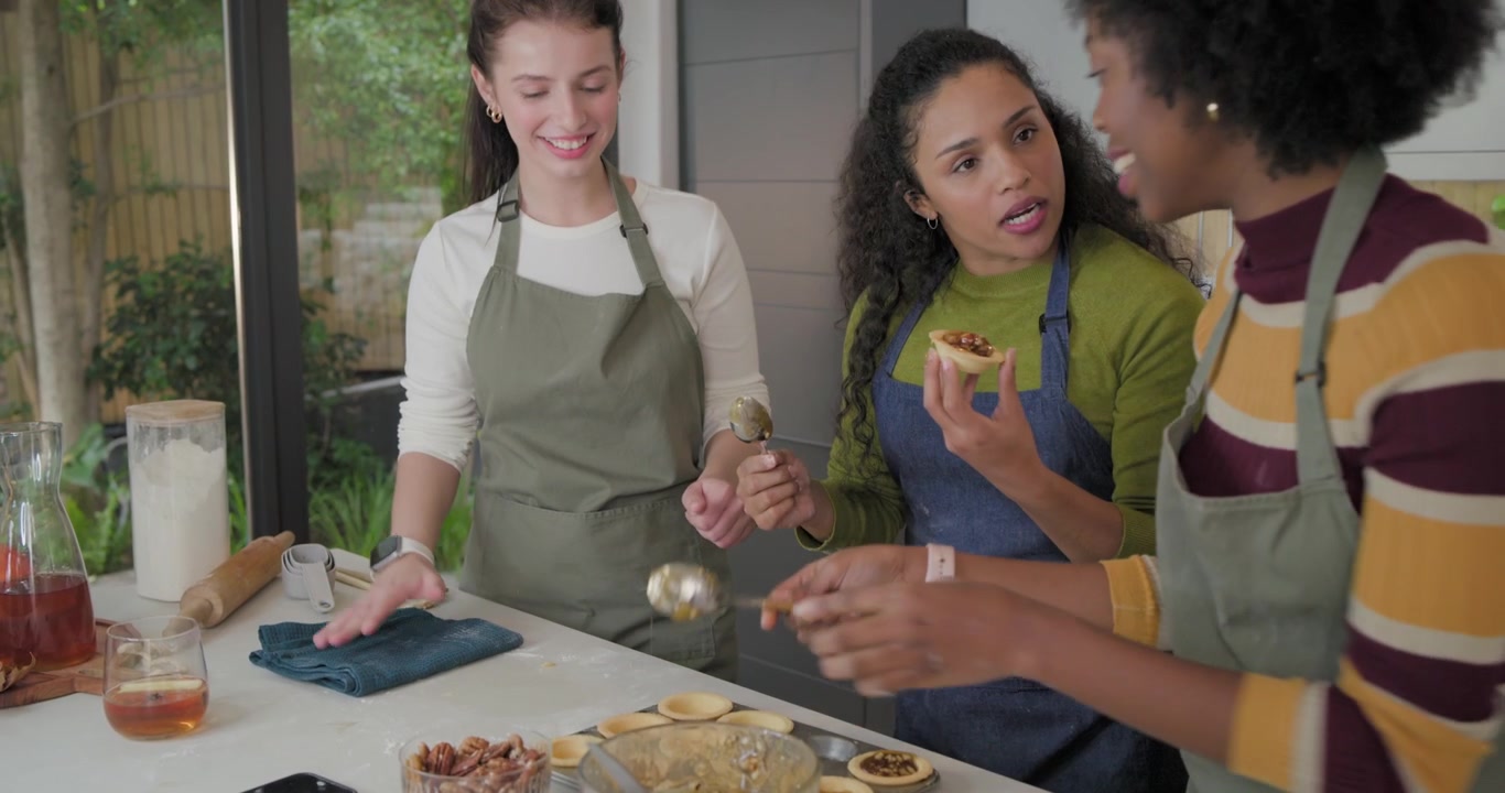 Vendo uma tigela de caramelo, mulheres africanas de avental colocando em casquinhas de torta, provando o sabor em casa
