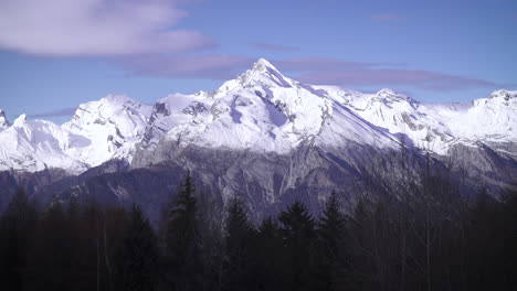 4k clouds passing over snowy mountain peaks in ski resort