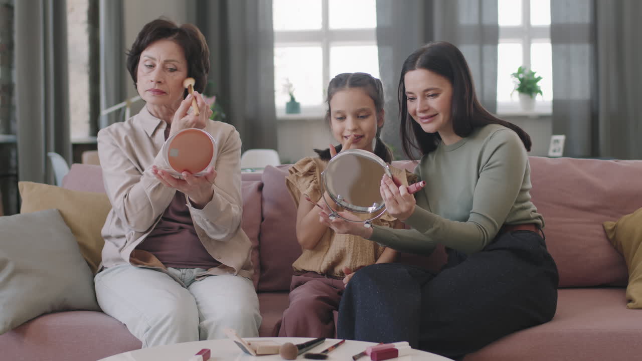 Three generations of women applying makeup