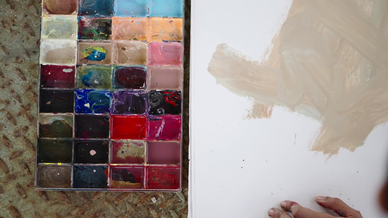 Close-up of an Artist's Palette and Hand Painting