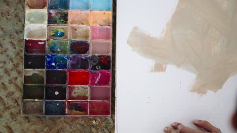close-up of an artist's palette and hand painting