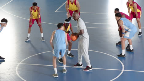 basketball coach guiding players during practice game on indoor court