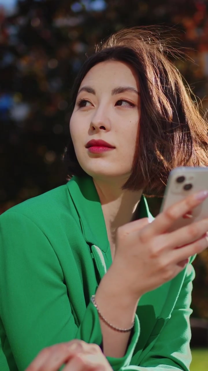 Giovane donna che usa lo smartphone all'aperto in una giornata di sole