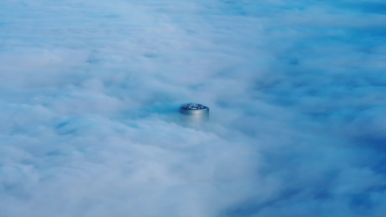 Lone skyscraper floats above thick fog cover in the silent dawn of Riga