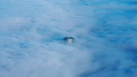 lone skyscraper floats above thick fog cover in the silent dawn of riga