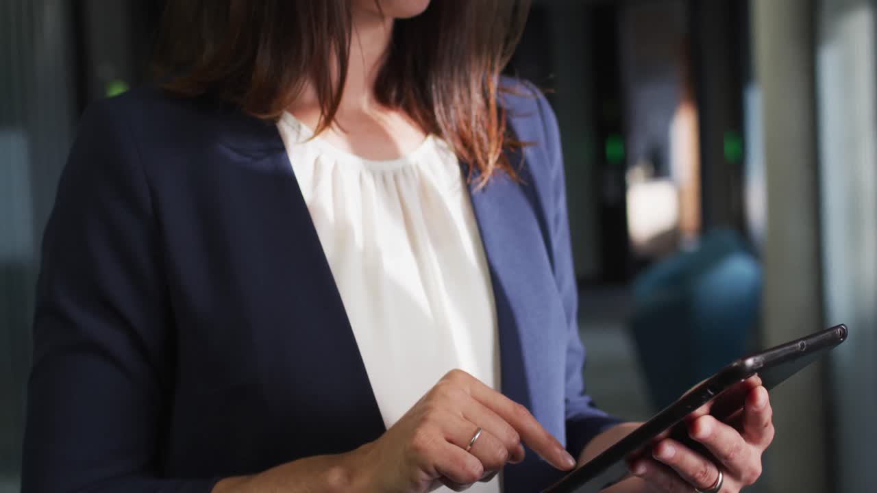 Portrait of smiling caucasian businesswoman using tablet in modern office