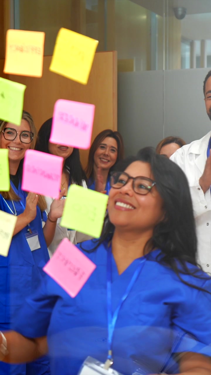 Team medico che celebra il successo con post-it su vetro