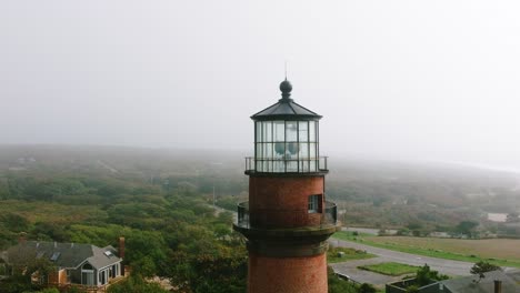 aerial drone pull back from gay head lighthouse on martha's vineyard into foggy ocean