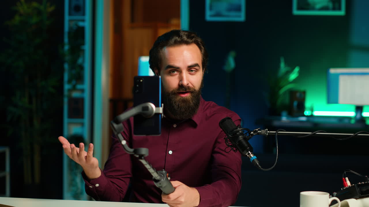hombre expresivo usando un teléfono inteligente en un palo de selfie para grabar video