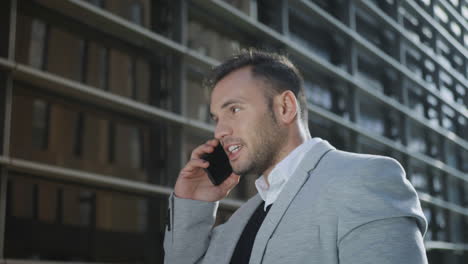 businessman talking on smartphone at street. employee using phone outside