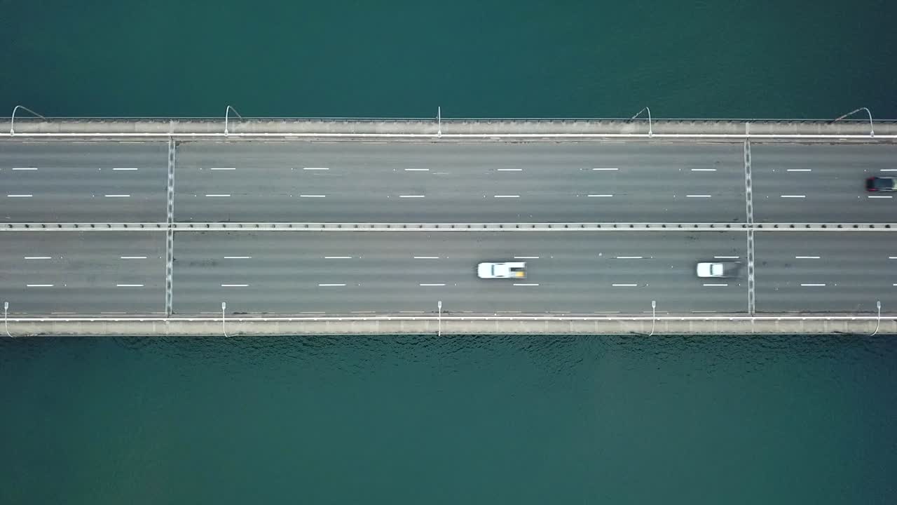 항공: 호주 시드니에 있는 캡틴 쿡 다리를 가로질러 운전하는 자동차와 한 명의 자전거 타는 사람의 조감도 드론 샷