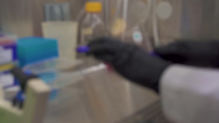 clip sfocata di uno scienziato che scrive su matracci di coltura tissutale