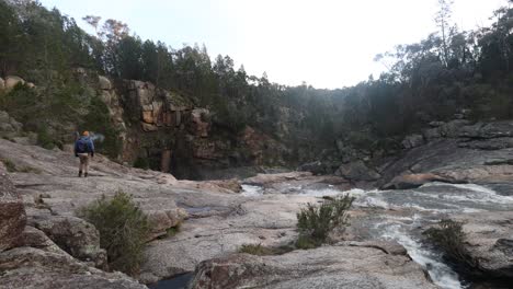 Ein-Buschmann,-Der-Eine-Pfeife-Raucht,-Während-Er-Einen-Wasserfall-Im-Australischen-Busch-Erkundet