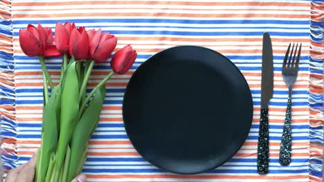 red tulip flower and cutlery on plate on table