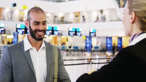hombre de negocios mostrando su tarjeta de embarque en el mostrador de facturación