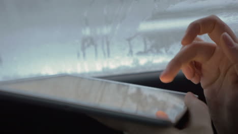 Woman-typing-on-tablet-computer-in-the-car