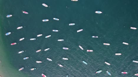 Top-down-aerial-view-of-boats-moored-off-the-shore-of-Puerto-Escondido,-Mexico