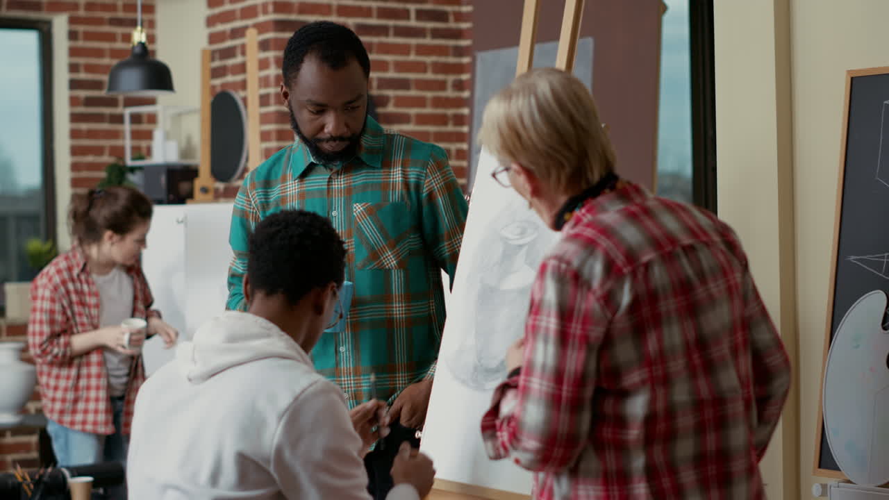 Team of students discussing sketch drawing with old artist