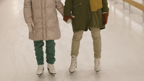 mother and daughter ice skating at night