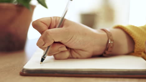 mujer, mano y cuaderno escribiendo en papel en casa