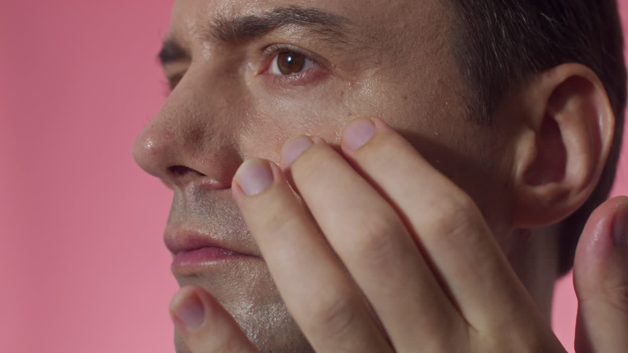 Caucasian Man Using Nourishing Serum on under Eyes Area