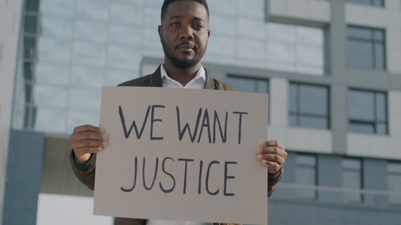 Man holding a sign protesting for Justice