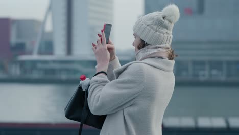 Female-tourist-taking-pictures-of-the-city-of-Rotterdam-on-a-cold-and-overcast-day