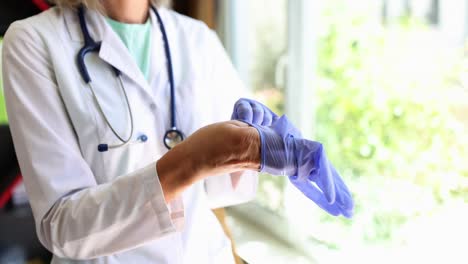 medical professional putting on blue gloves