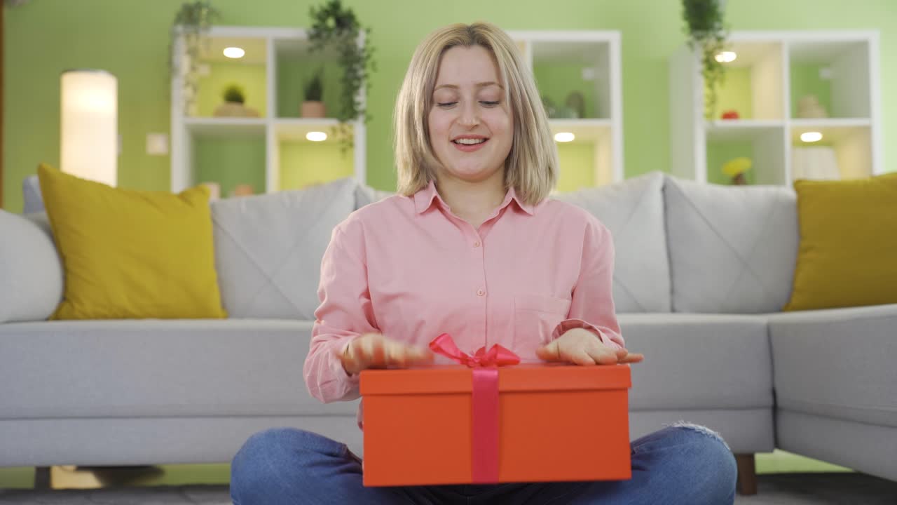 선물 포장을 열고 있는 어린 소녀