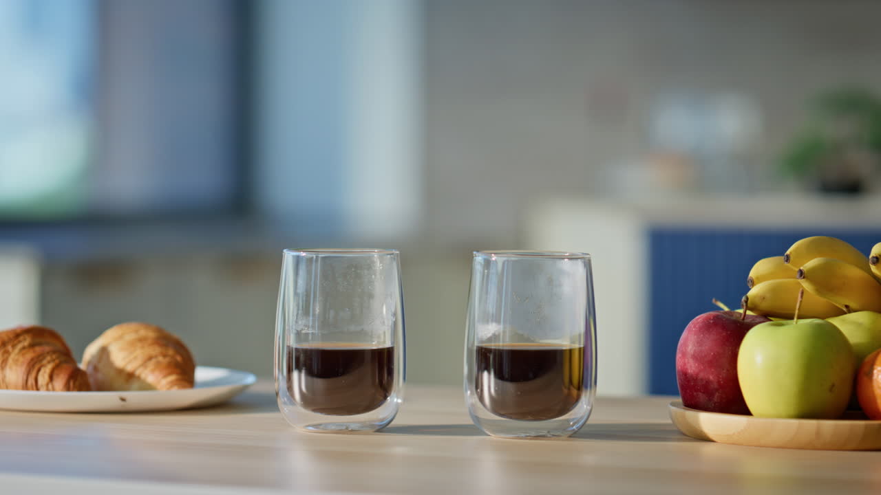 Closeup two cups coffee on wooden table. Croissants fresh fruit for breakfast
