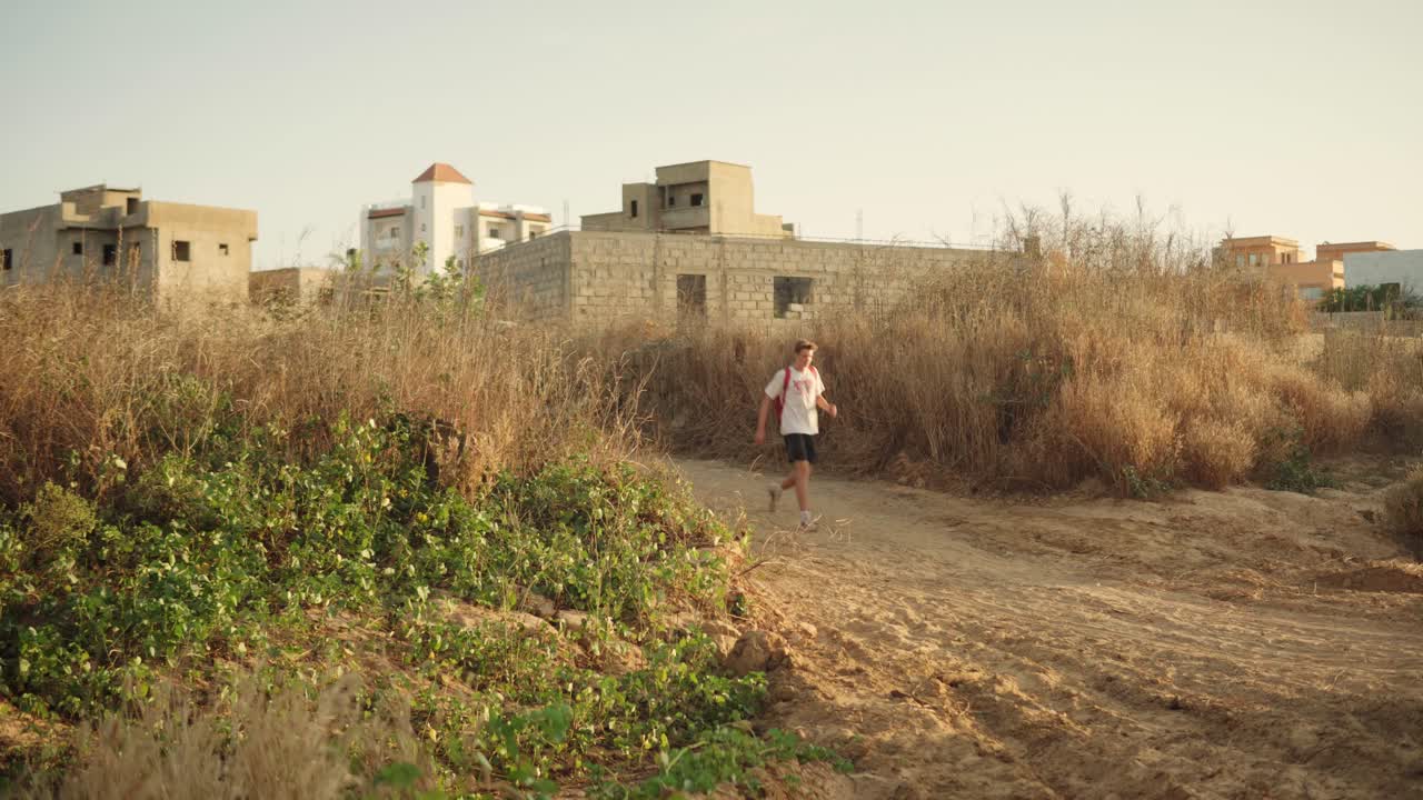 Uomo bianco cammina lungo un sentiero sterrato in Senegal, Africa
