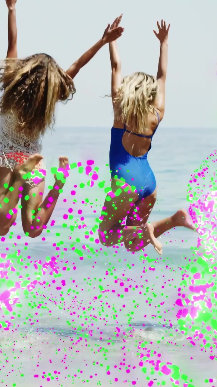 Vertical video: Two women at shore, slowing, leaping into sea for travel, confetti on legs, walking