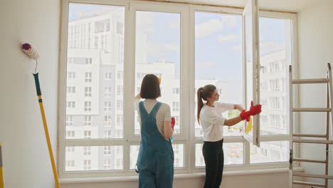dos mujeres limpiando ventanas