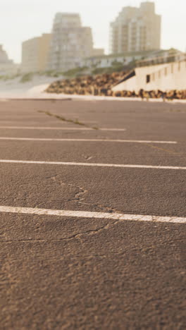 estacionamiento vacío junto a la playa con la ciudad en el fondo