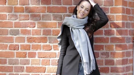 beautiful woman leaning on brick wall